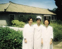 Farmas&oslash;yt, lege og jordmor foran urtehagen til Jangsuwon ri-clinic. Alle foto privat