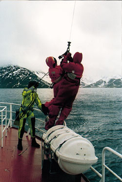 To personer fra en fiskesk&oslash;yte blir spent fast til en vaier og heist opp i Sea King-helikopteret under en &laquo;pickup&raquo;-&oslash;velse i&hellip;