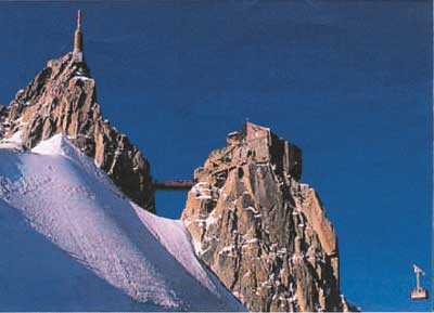 Aiguille du Midi. Den ene toppen kan n&aring;s med gondolheis fra Frankrike, den andre fra Italia. En gondol er p&aring; vei opp