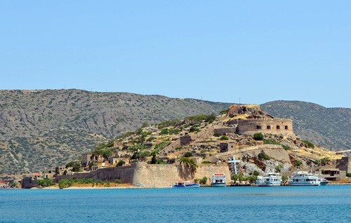 Spinalonga er den lille &oslash;ya med et stort festningsverk. Bak disse murene holdt man bortimot 1 000 spedalske internert i&hellip;