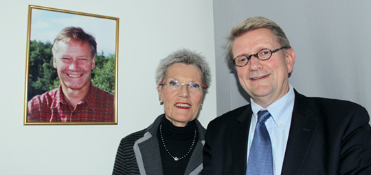 Tove Rutle og Geir Riise foran fotoet av Olav Rutle. Foto Lise B. Johannessen