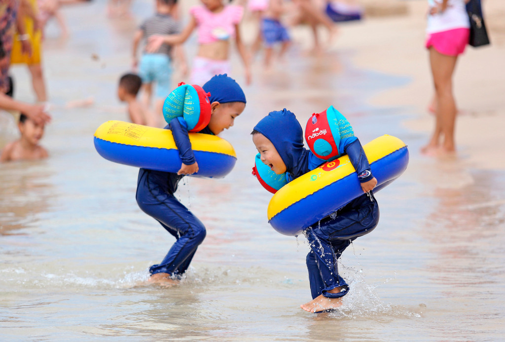 Barn leker p&aring; en strand i Sanya i Hainan-provinsen, S&oslash;r-Kina. Foto: Sipausa/NTB Scanpix