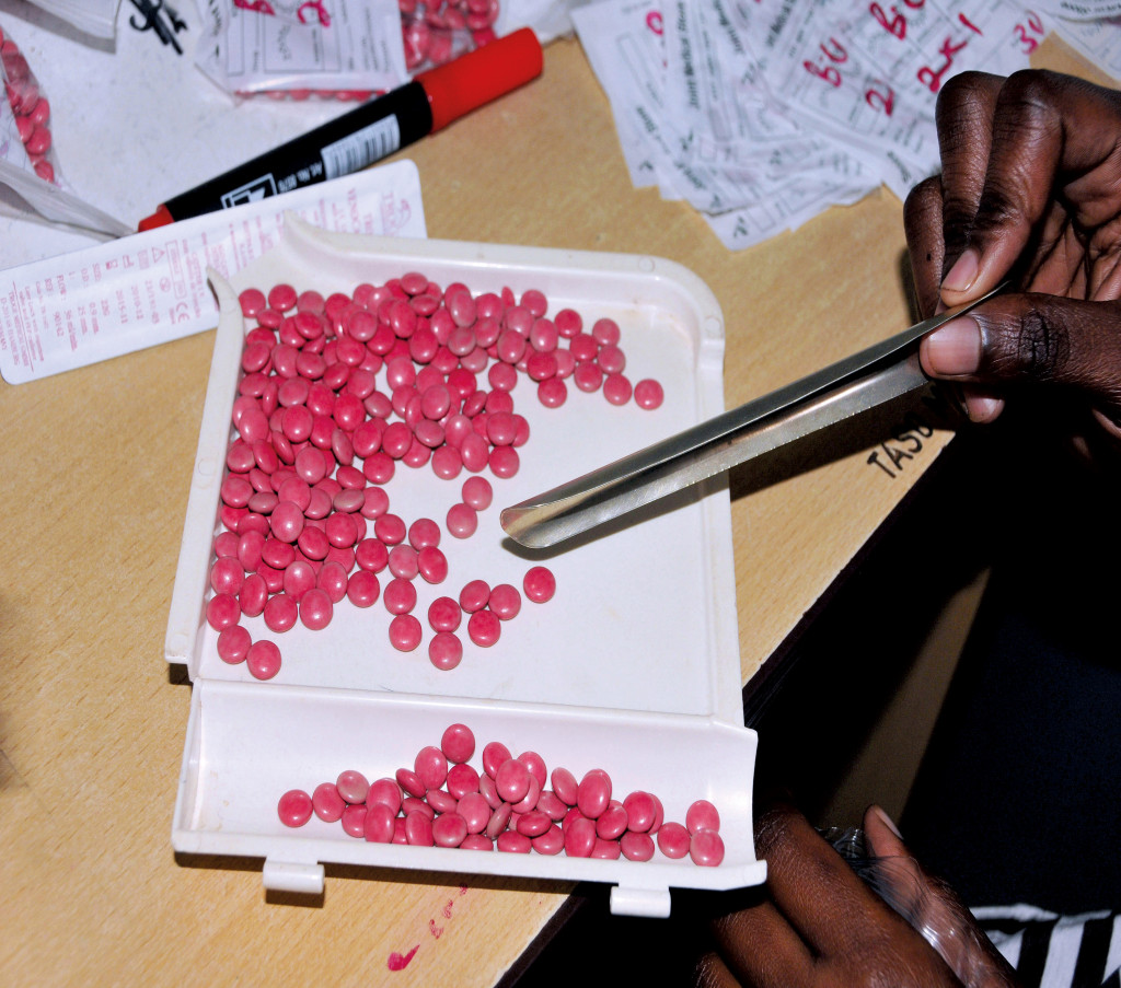 En helsearbeider teller opp antiretrovirale tabletter til en pasient ved AIDS Support Organization (TASO) i Ugandas&hellip;