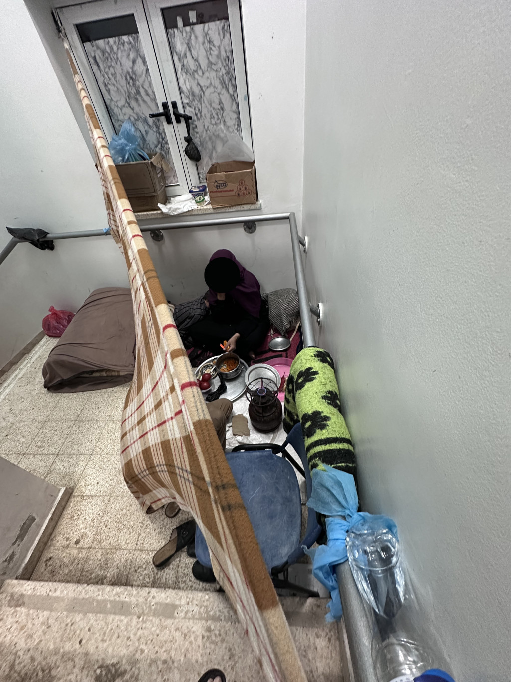 Kvinne som lager mat i sykehustrappen p&aring; European Gaza Hospital. Foto: Geir Stray Andreassen.
